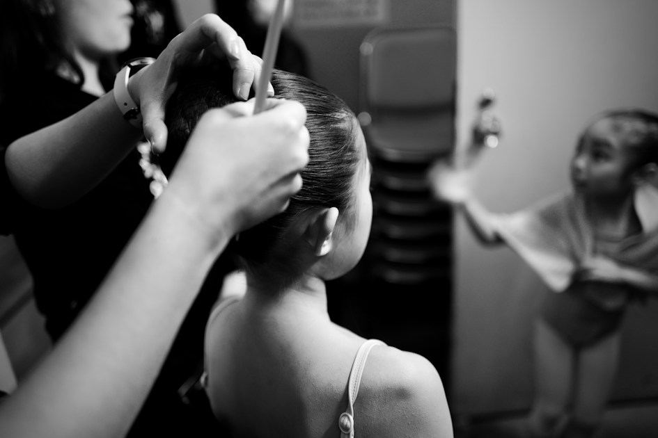 A woman cutting another woman's hair in a room