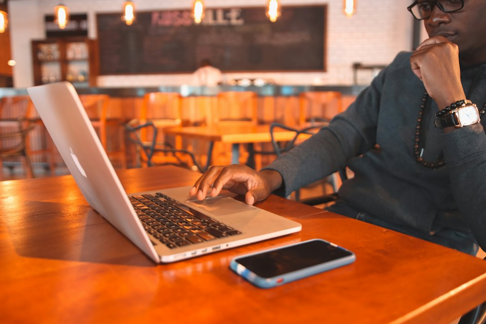 a man sitting at a table using a laptop computer