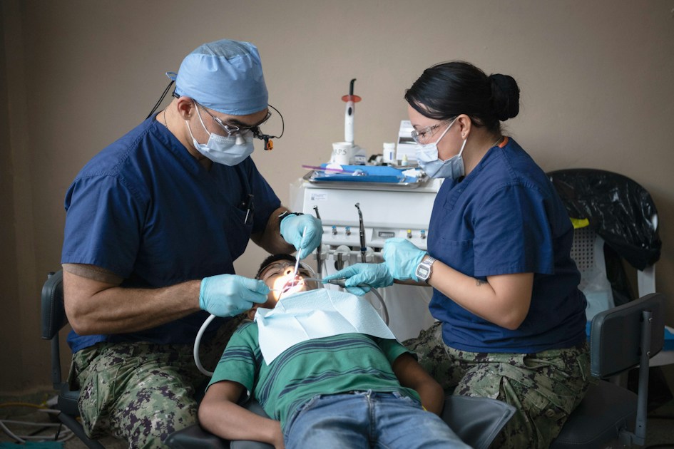 Dentists providing dental care to a patient