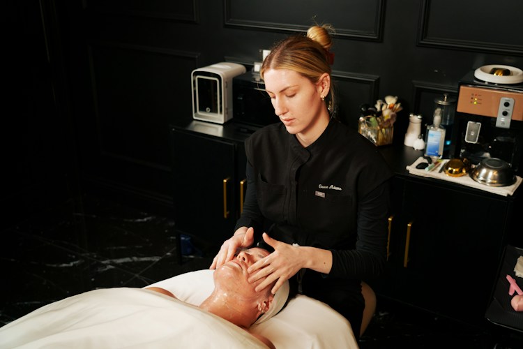 Esthetician performs a facial on a client