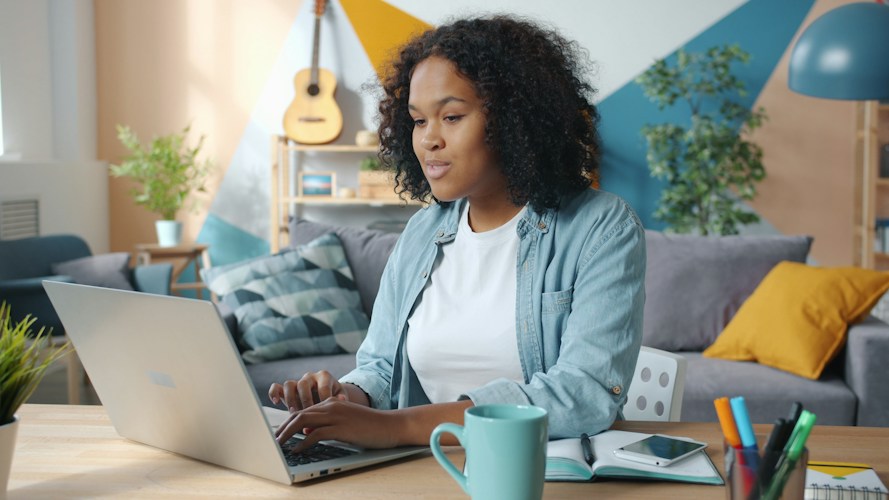 Woman working on a laptop in a cozy living room