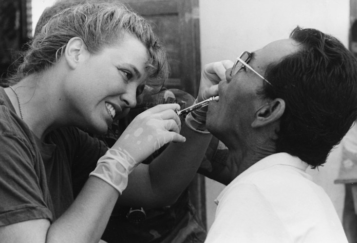 Dentist examines patient's teeth with tools