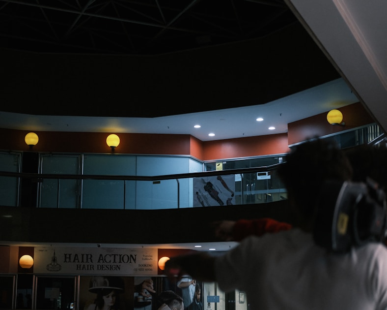 Person walking through a dimly lit multi-level indoor space.